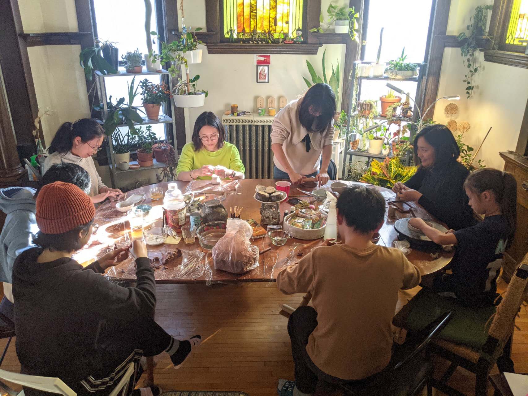 An image of people around a table working on ceramic projects.