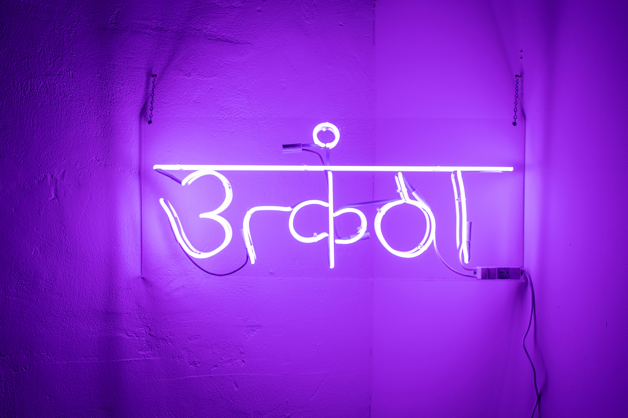 An image of a purple neon sign in Hindi.