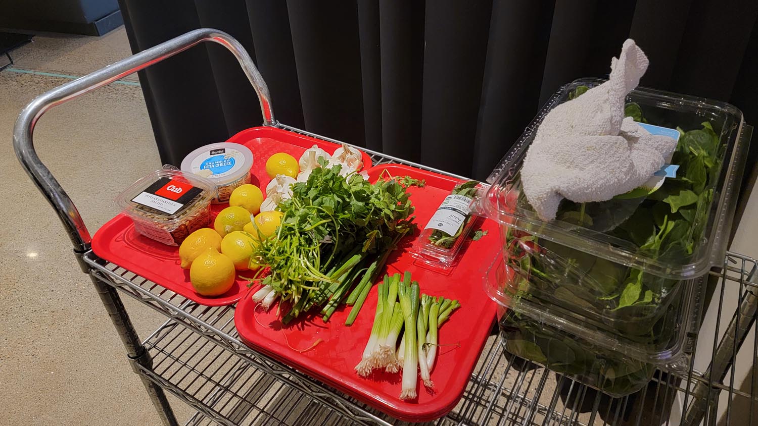 A table filled with fresh ingredients, the ingredients all lay on two red trays