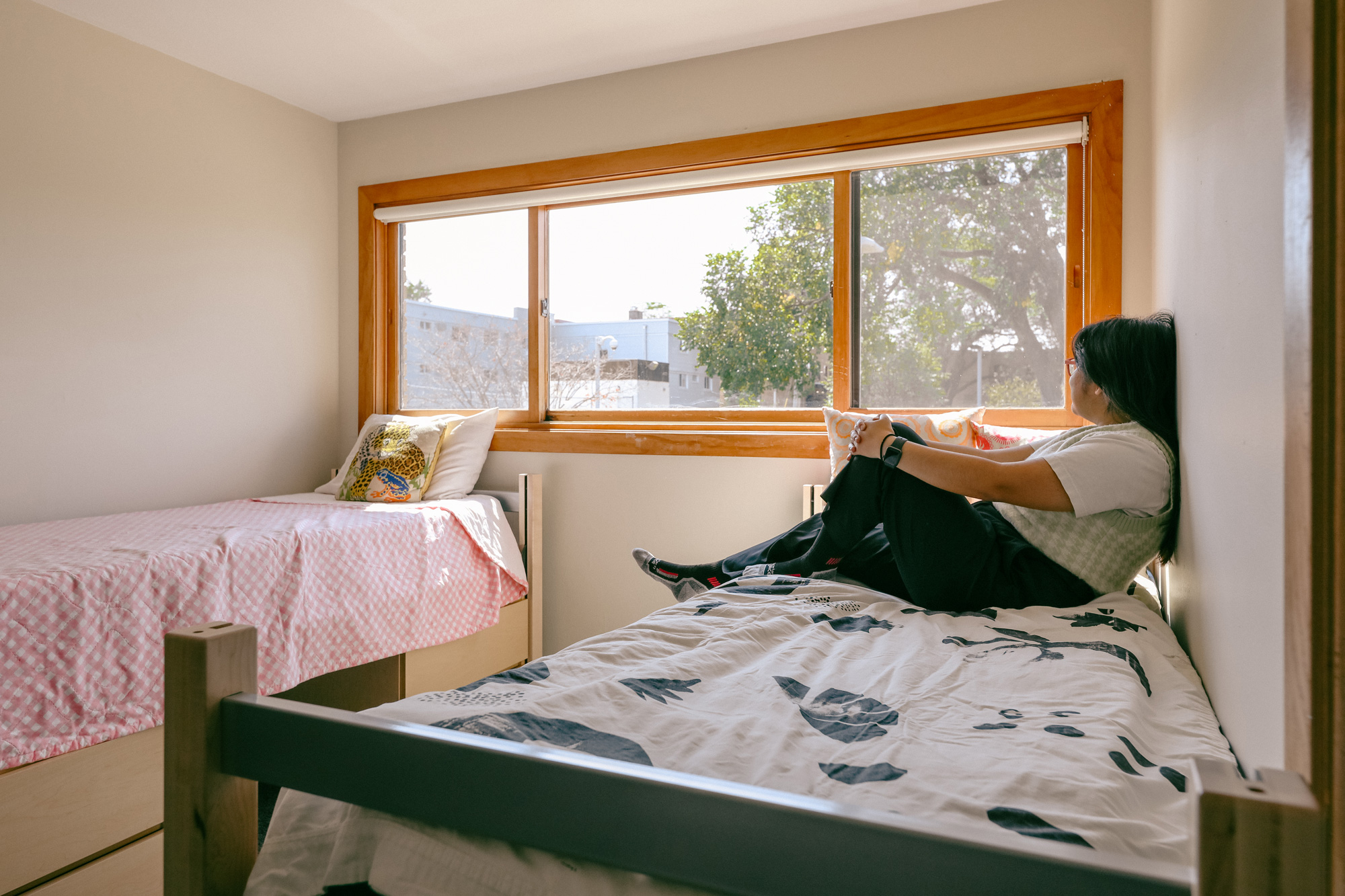 Student sitting on a bed in the triplets