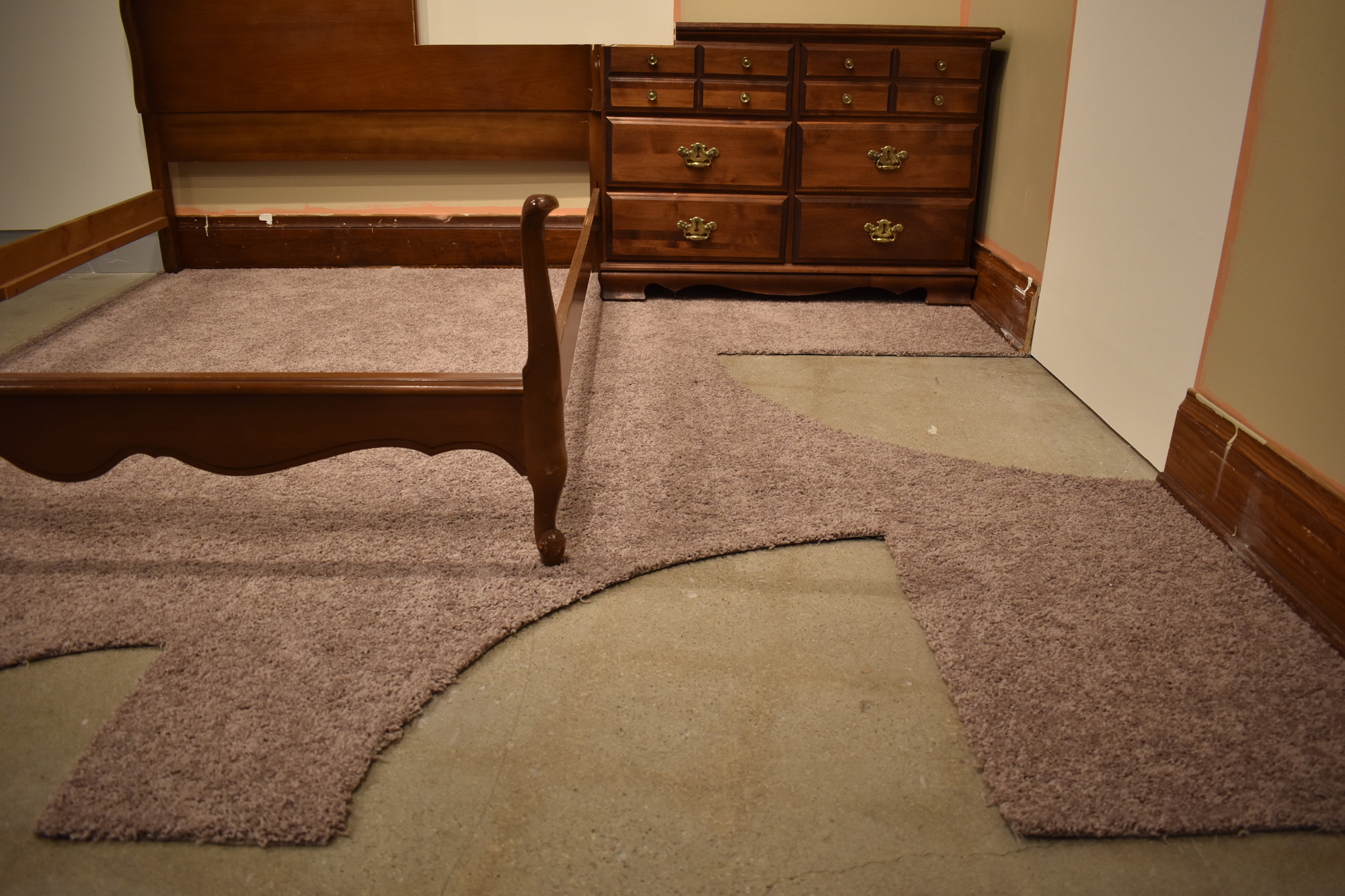 Installation featuring a bed frame and dresser