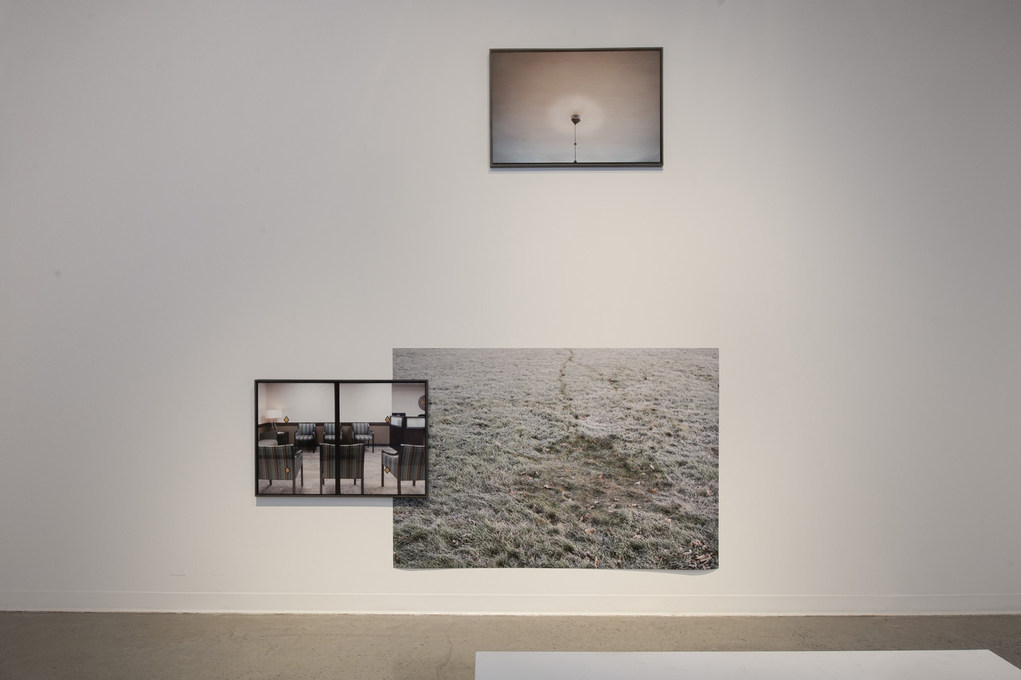 Photo of three photographs on a gallery wall