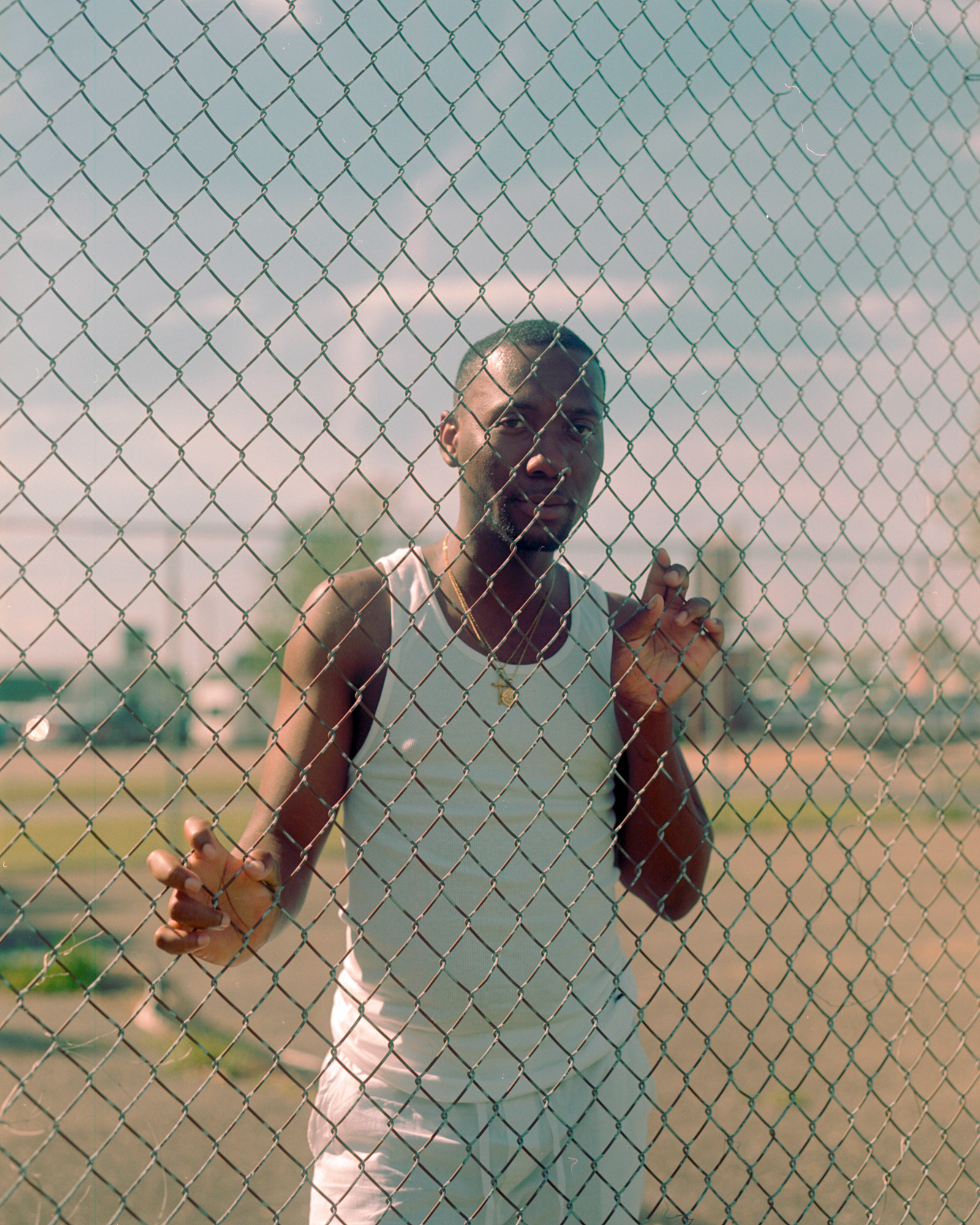 Photo of a person behind a chain link fence