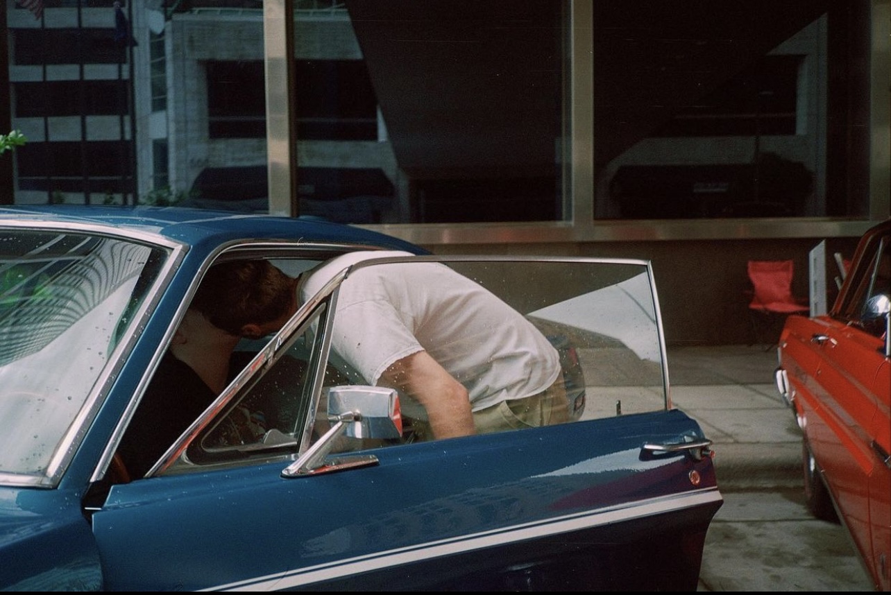 Photograph of someone getting into a car