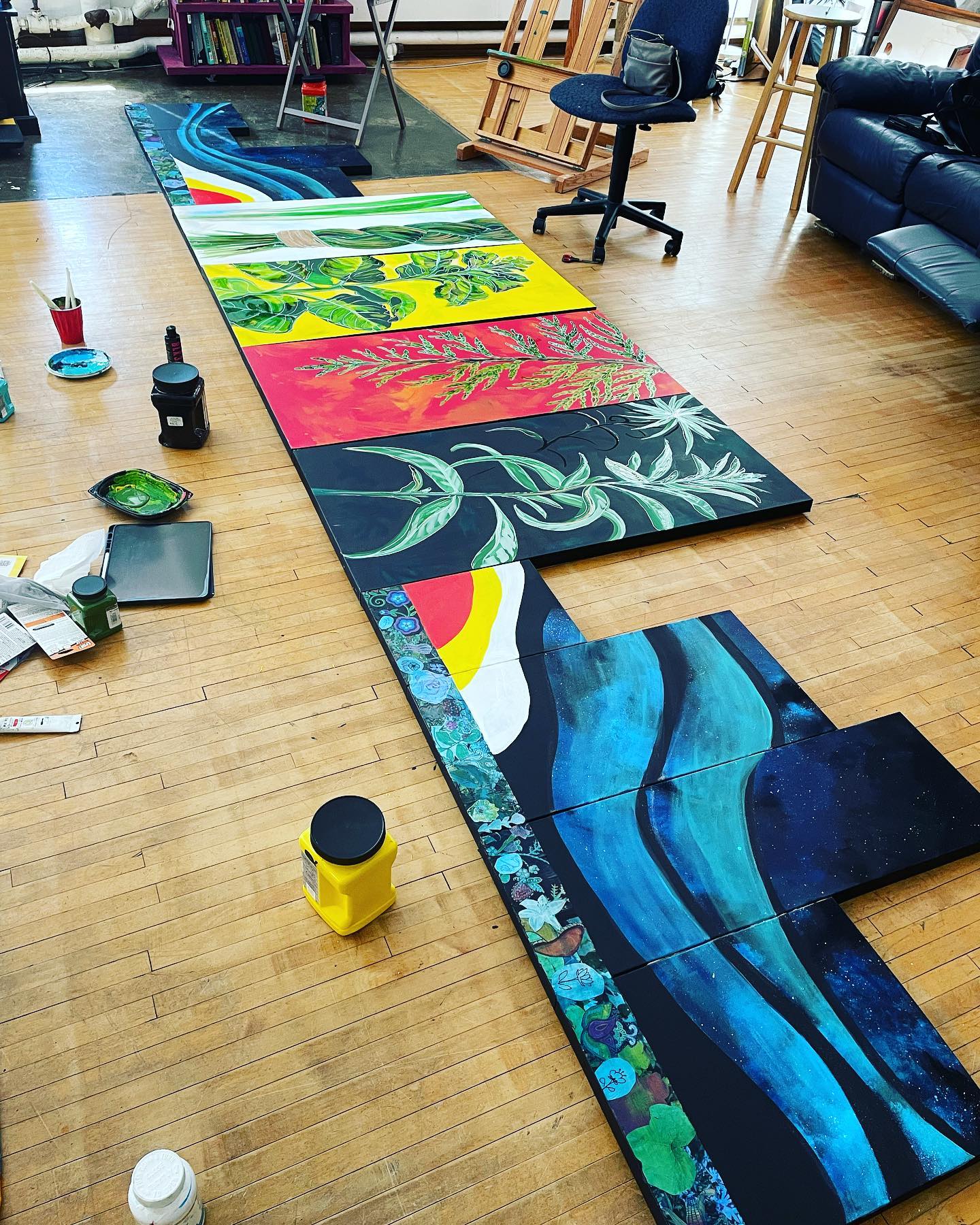 An image of paintings on a wooden floor.