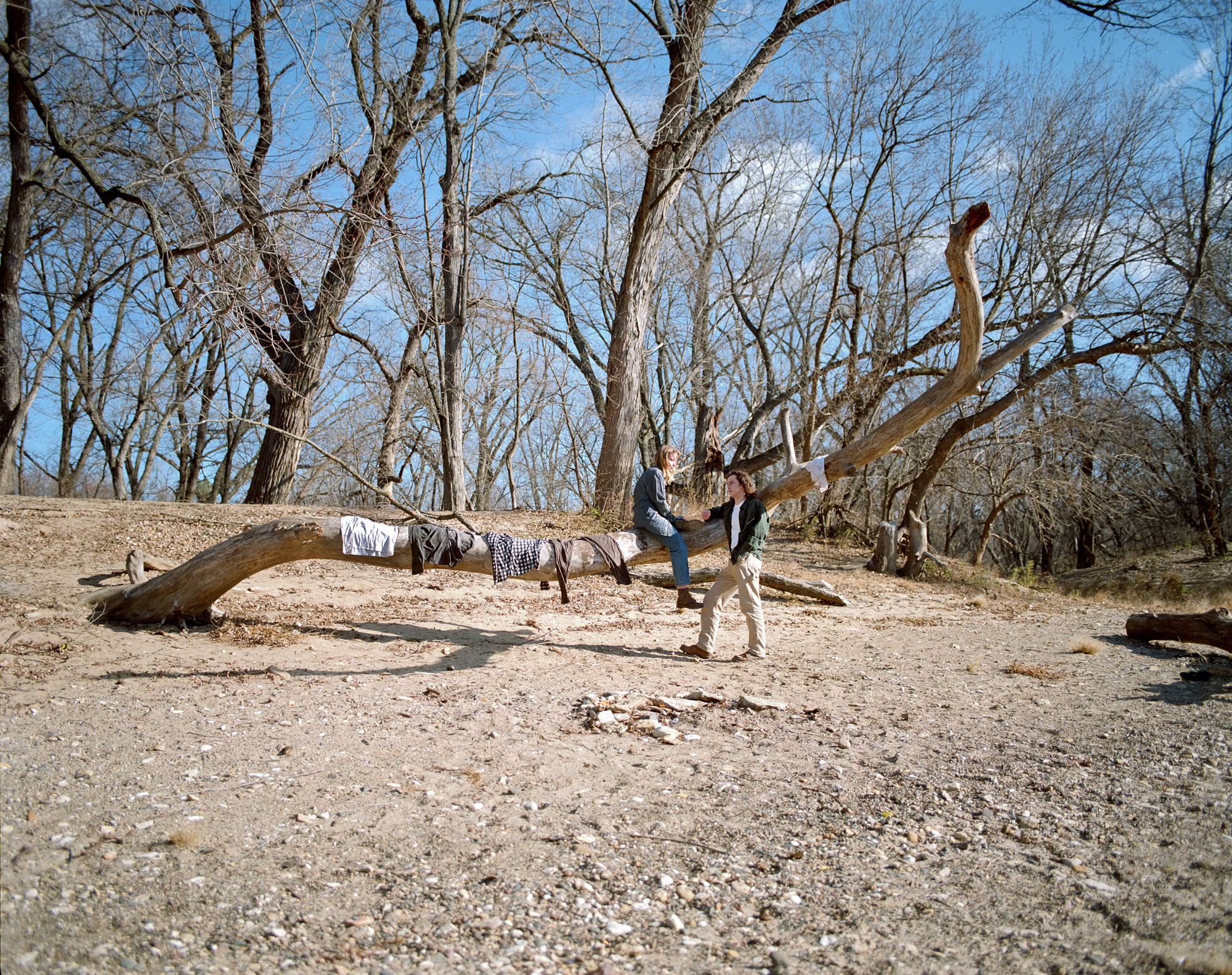 Two young adults in a barren forest