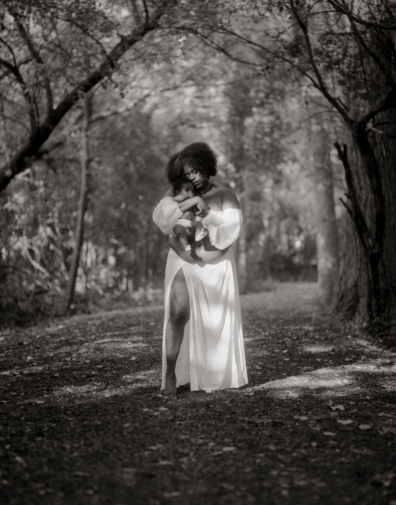 Photo of a woman standing in a field holding a child