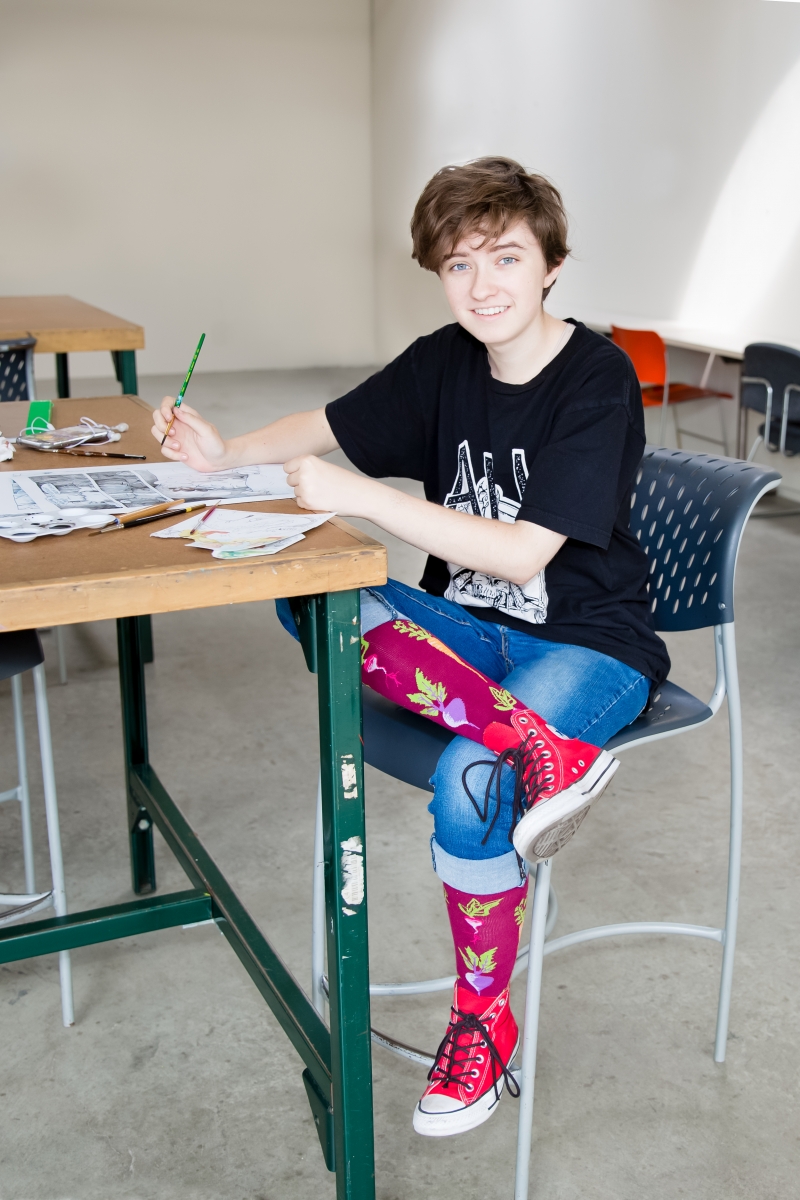 Orion works on one of their comics in an MCAD studio. Photo by Grace Olson.