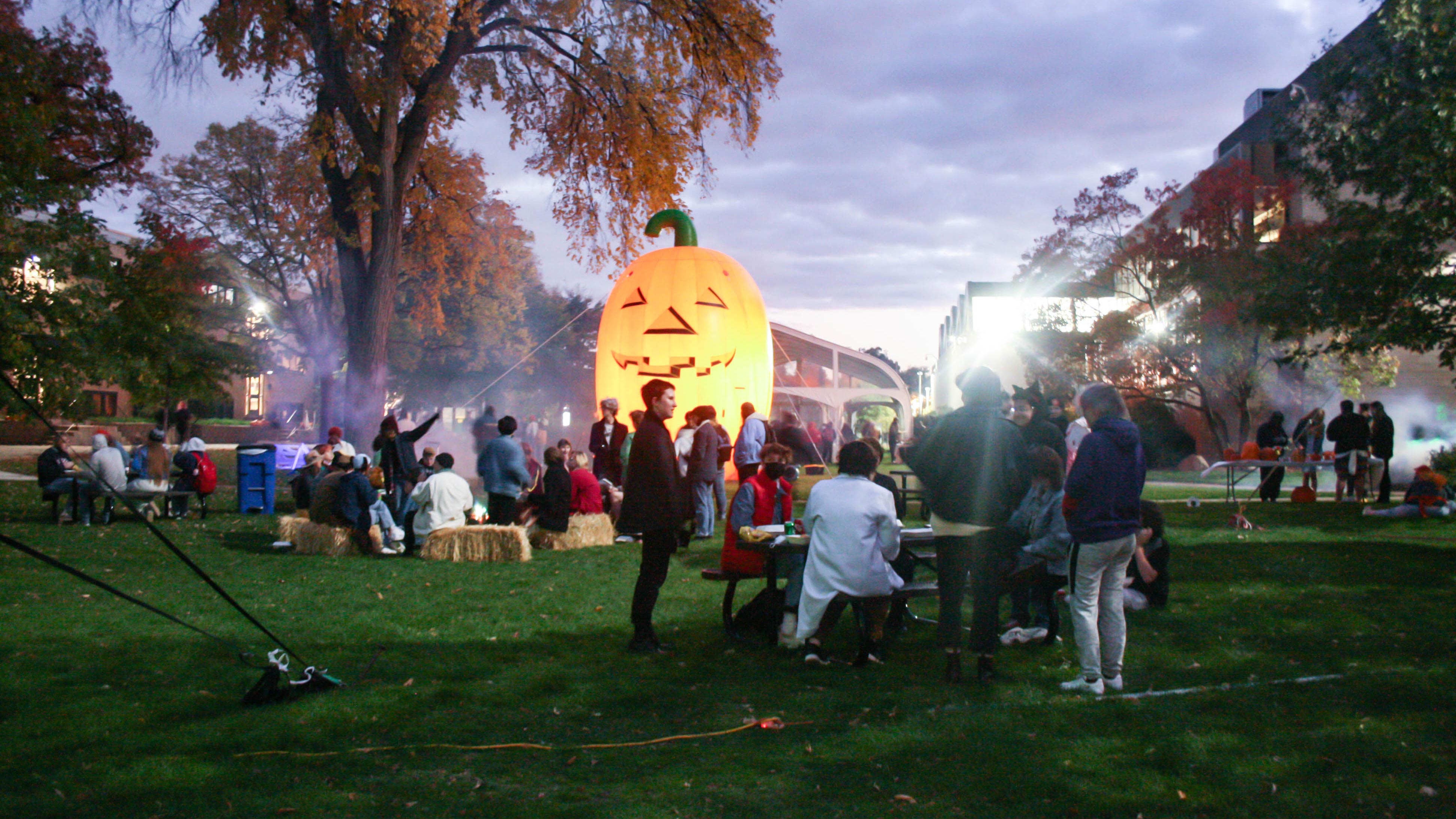 Students gathered on the MCAD lawn with a large inflatable Godzilla in the background.