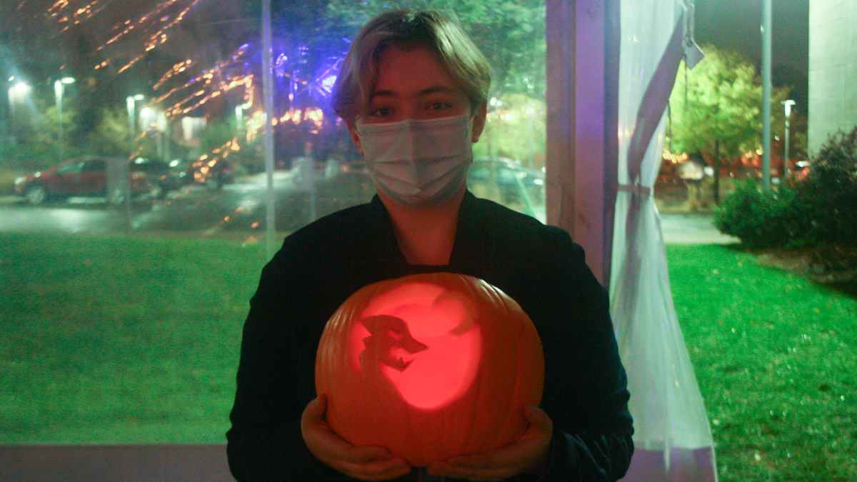 Student holding their carved pumpkin