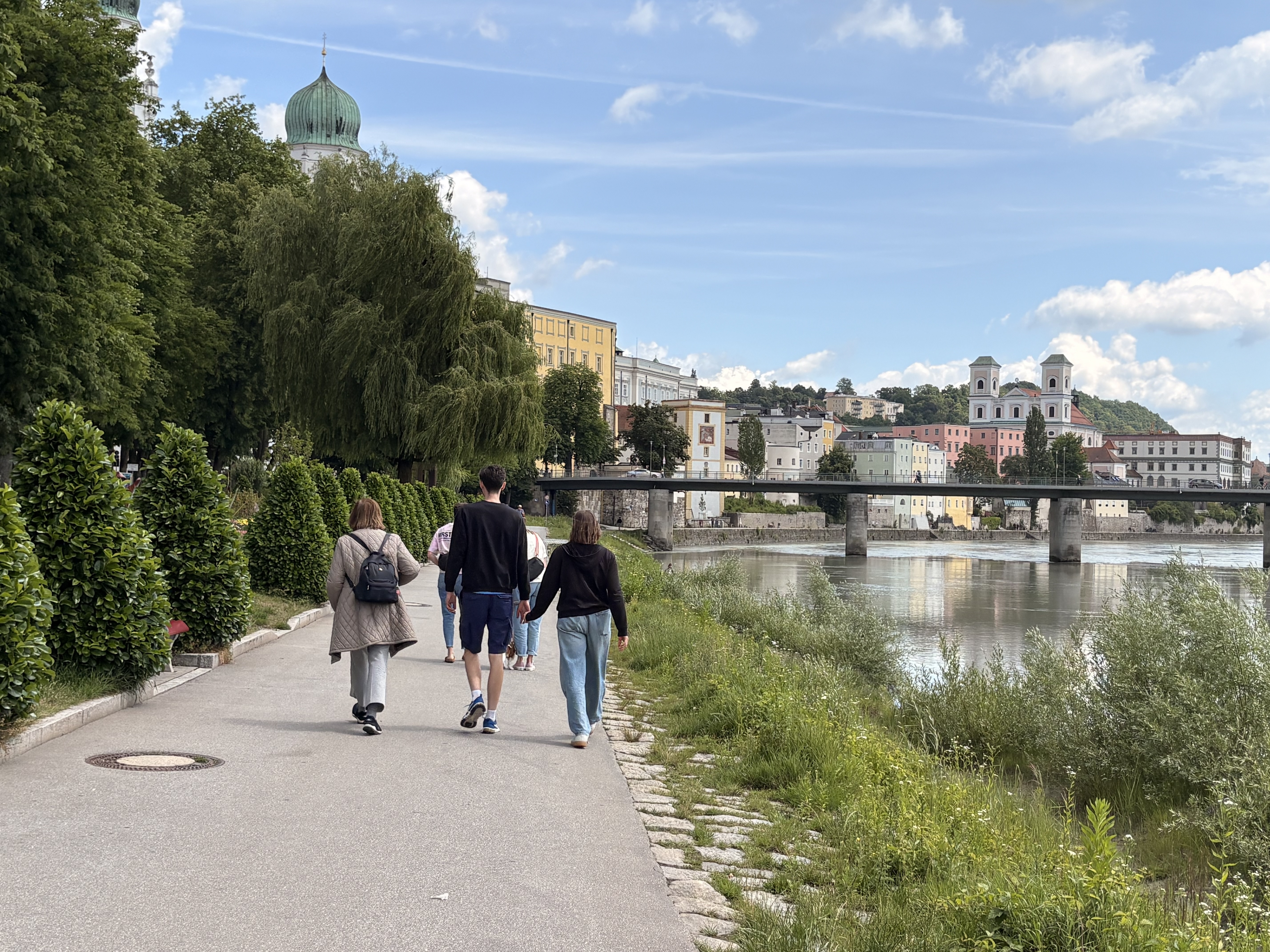 The Ilz River in Passau Germany with people walking on the side of the river