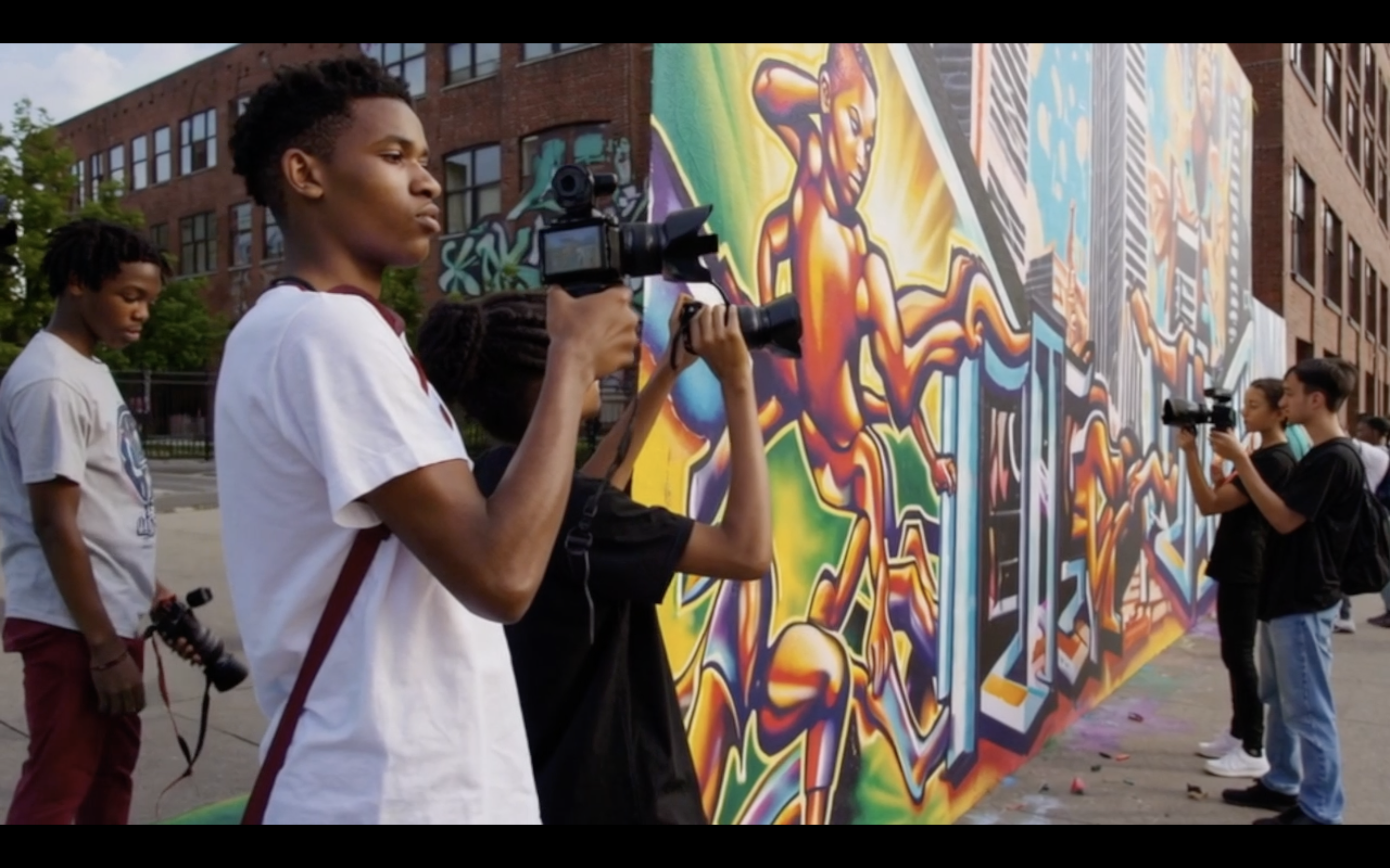 kids taking photos of a mural