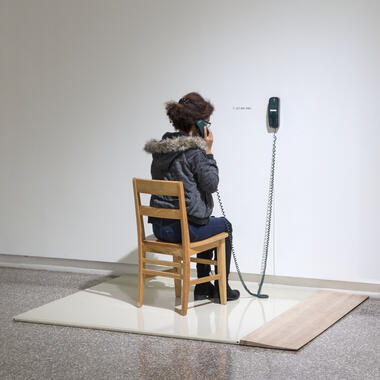 Emmett Ramstad, Untitled (Calling Station), 2016, bathroom stall partition, birch ramp, telephone, chair, phone, phone number, approx. 5' x 5' x 5'. Photo: Rik Sferra.