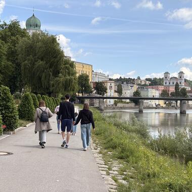 The Ilz River in Passau Germany with people walking on the side of the river