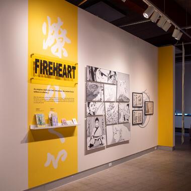 Installation of comic book, with comic section panels on the wall.