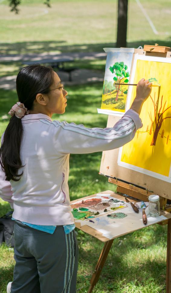 Person painting a landscape outside