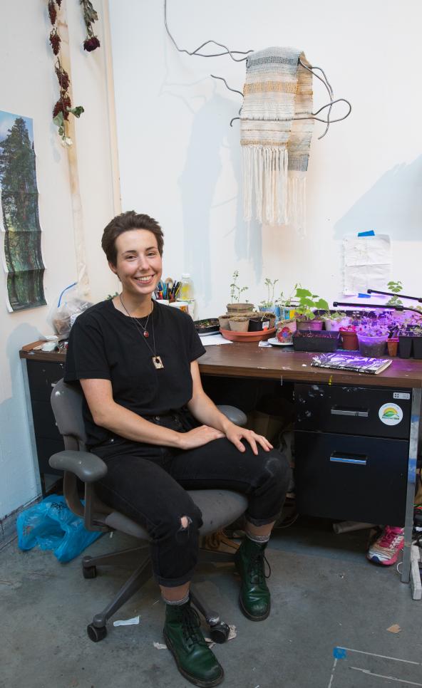 Student in their studio surrounded by their artwork