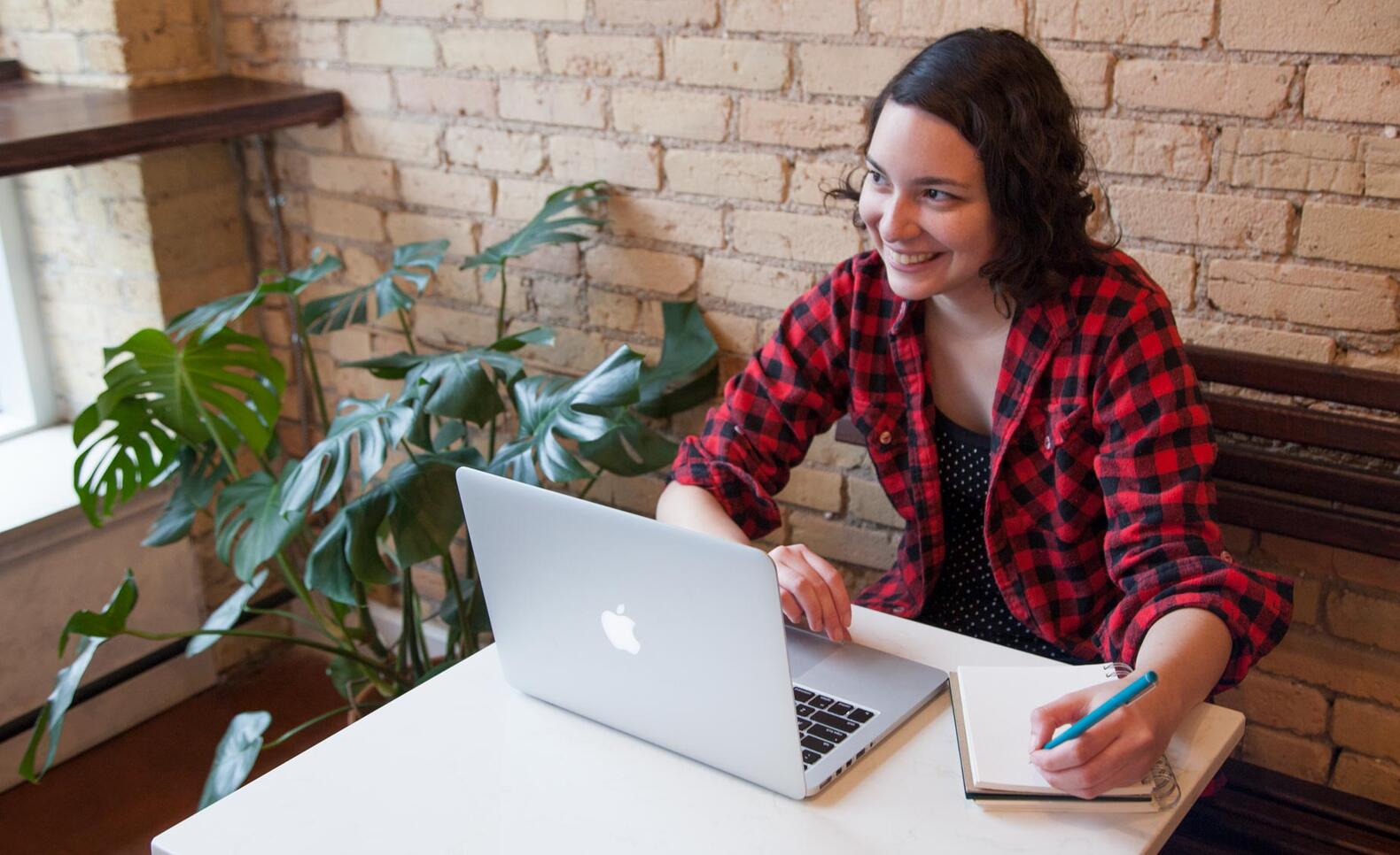 Student working in coffee shop at computer