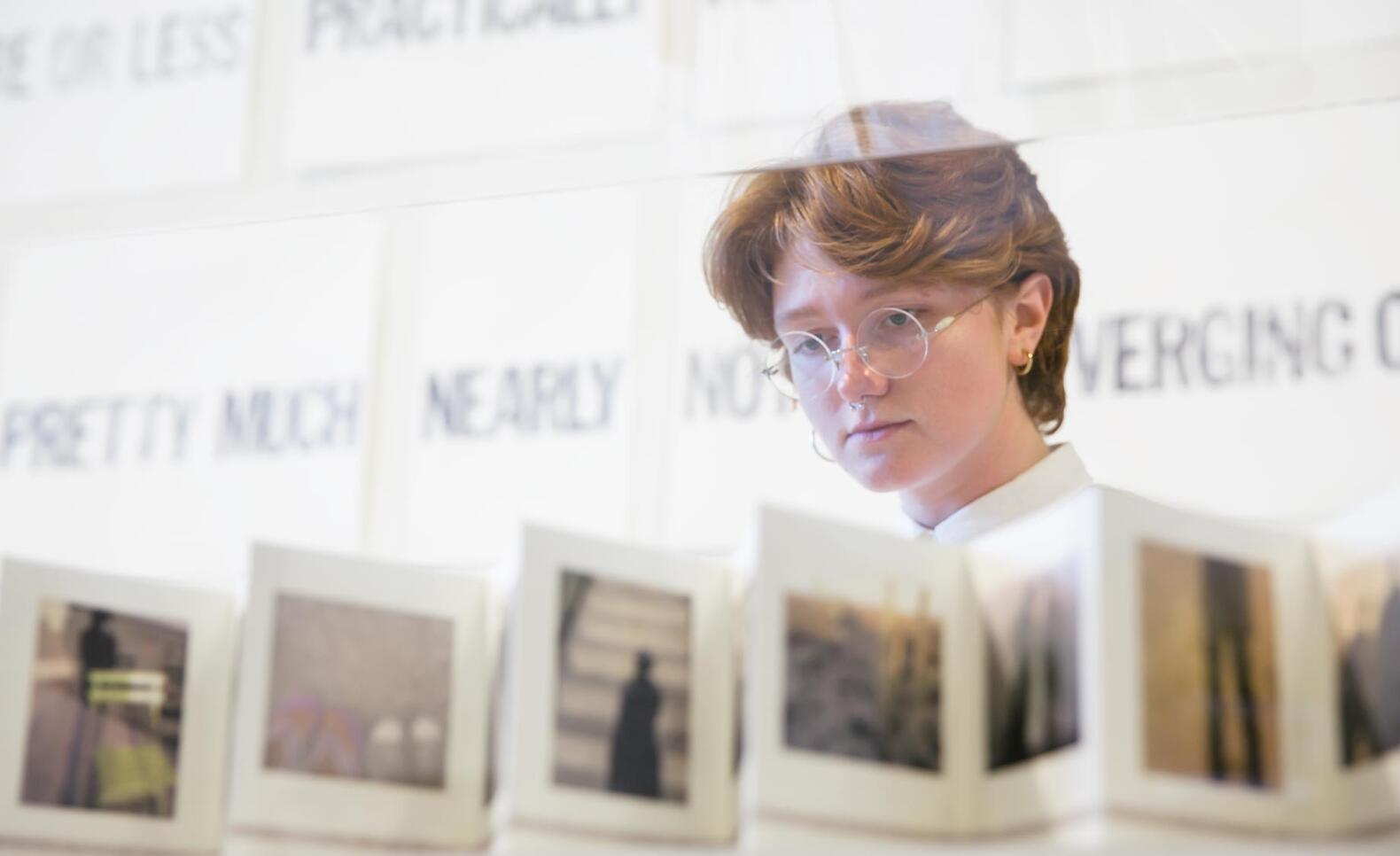 Person looking at an artist book at the MCAD Faculty Biennial