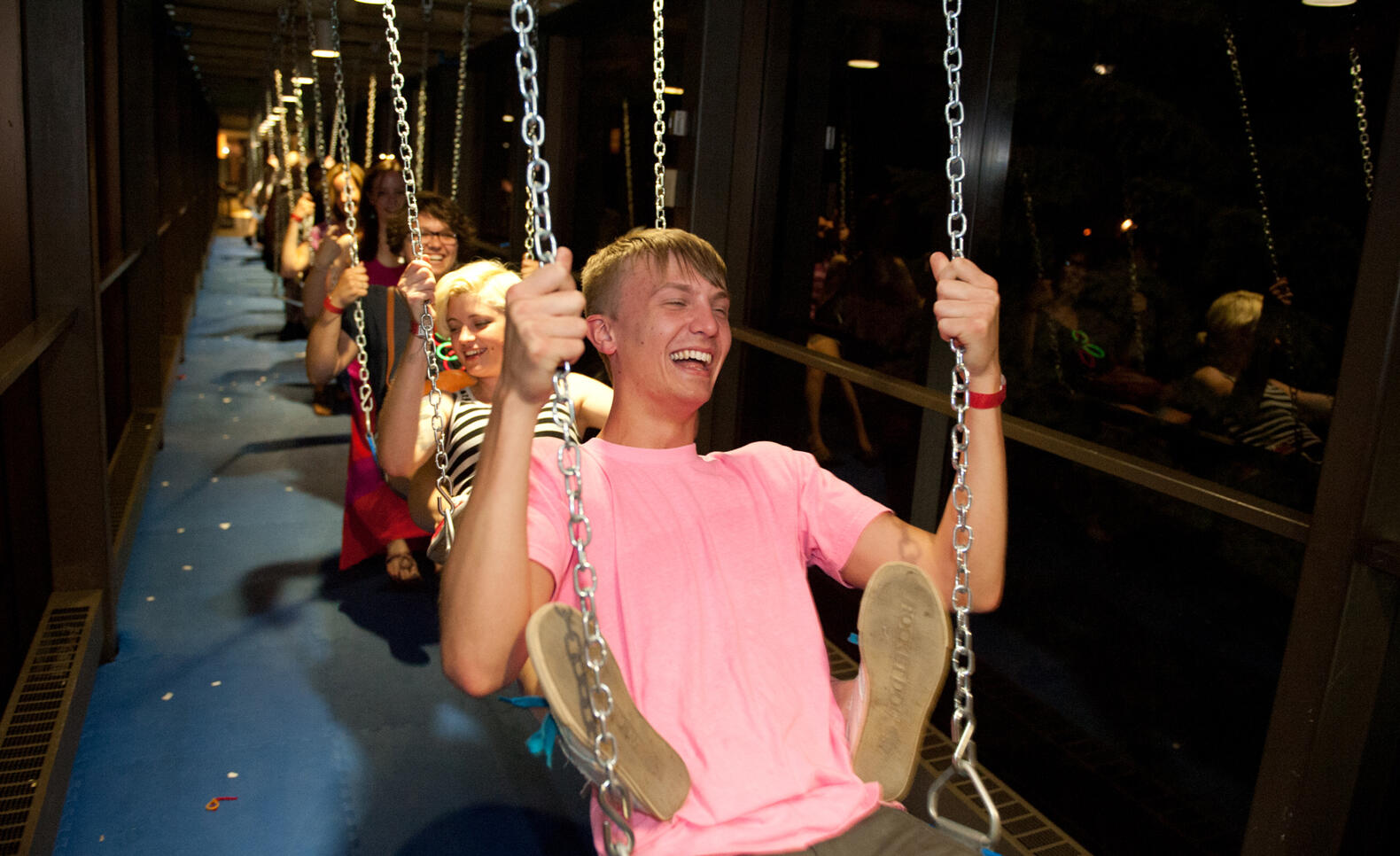 Students on swings in skyway during an event