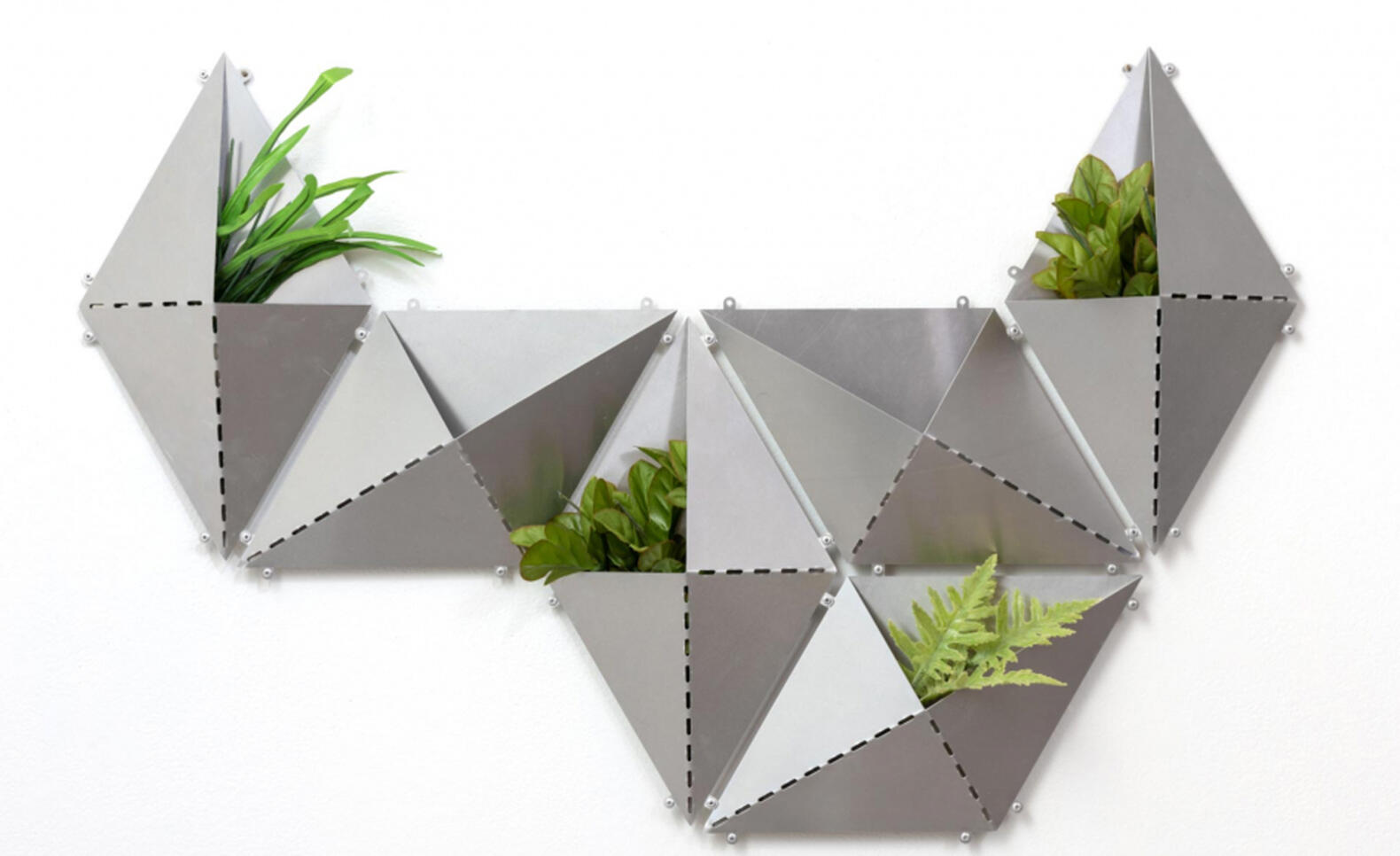 Laser cut aluminum piece made up of different rhombus shapes with plants in them ; Erin Moren