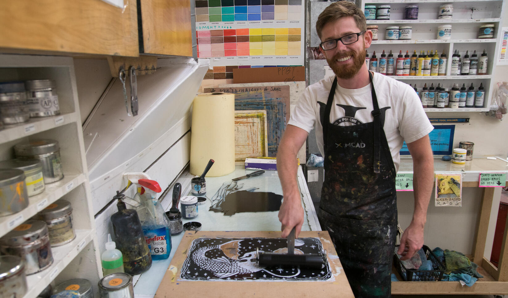 Art teacher inking a block to print