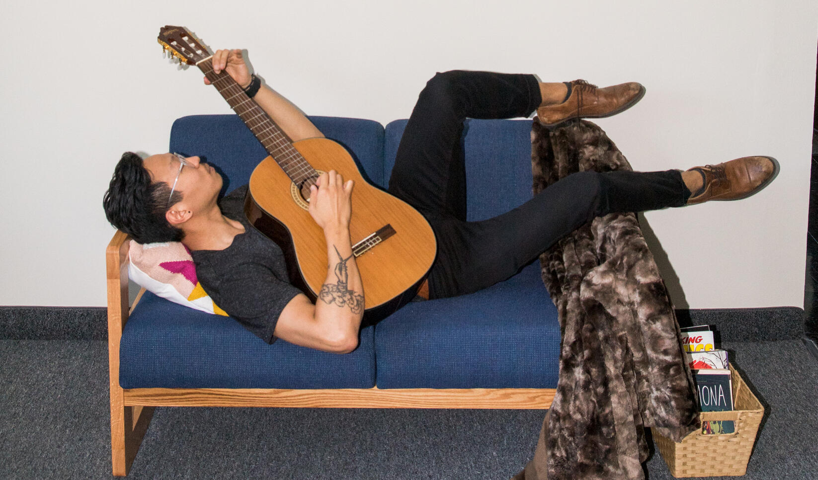 Person playing guitar on the couch