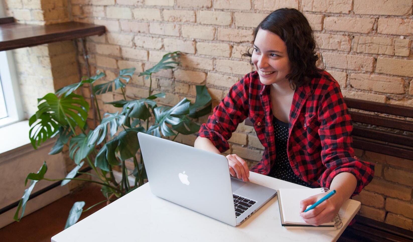 Student working in coffee shop at computer