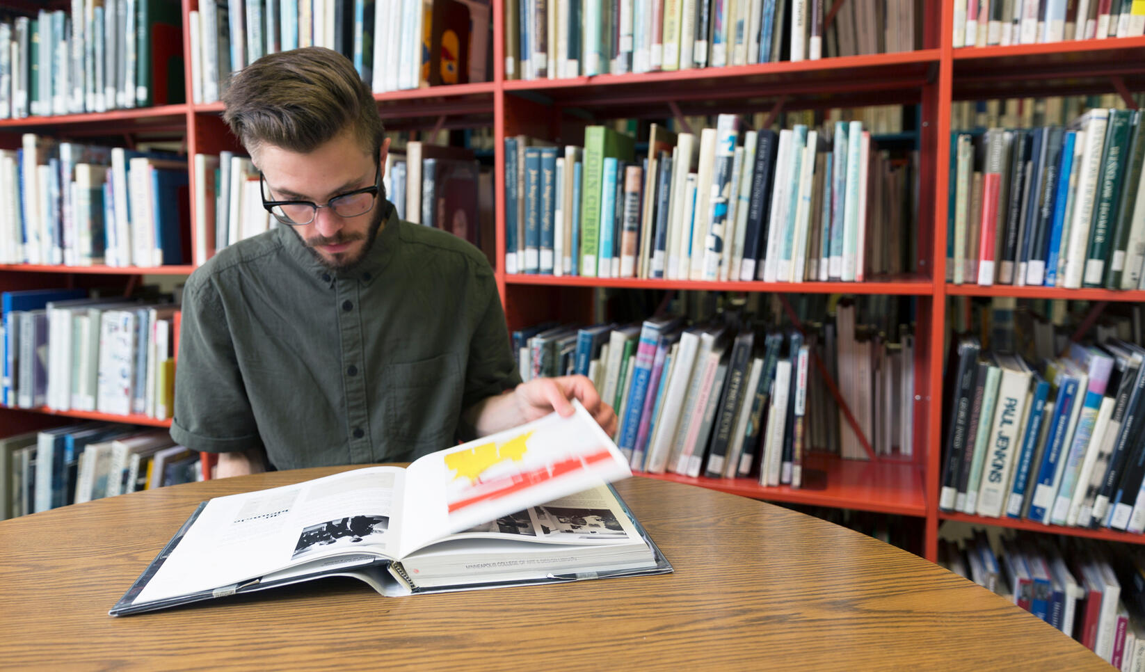 Person reading a book in the library