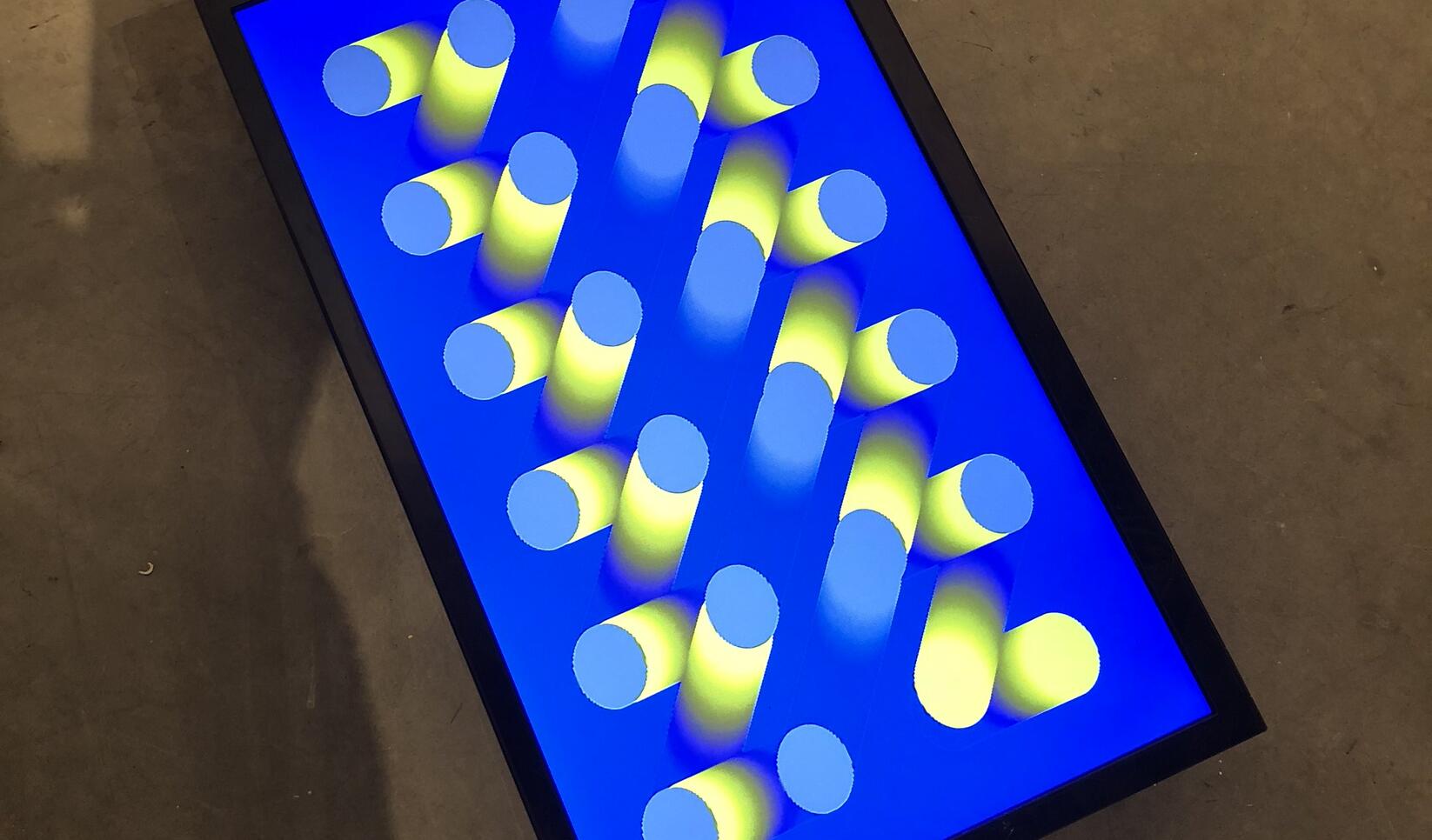 Image on a tablet of geometric shapes and fluorescent blues and yellows ; Yujie Cao