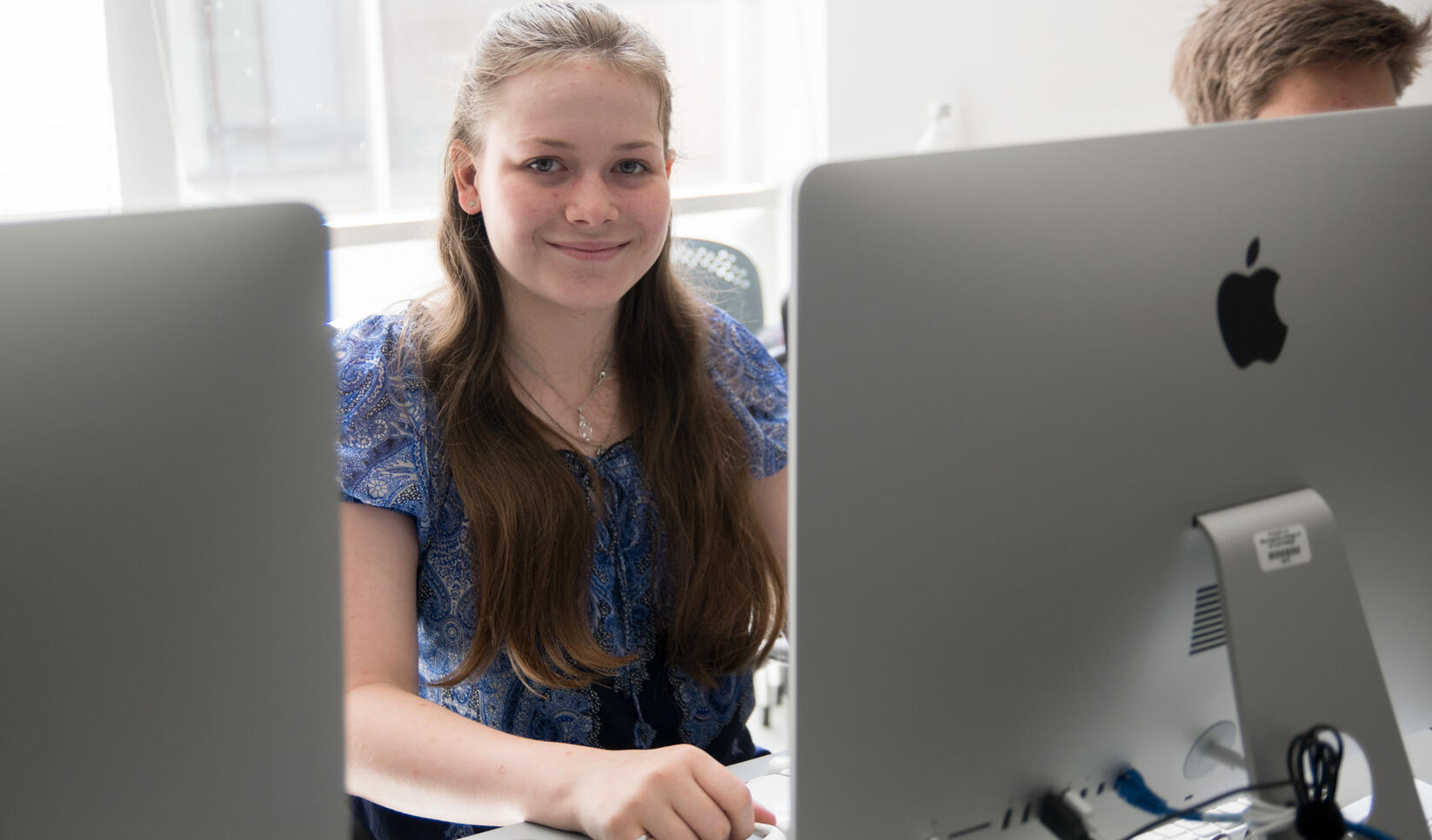 Student at computer smiling