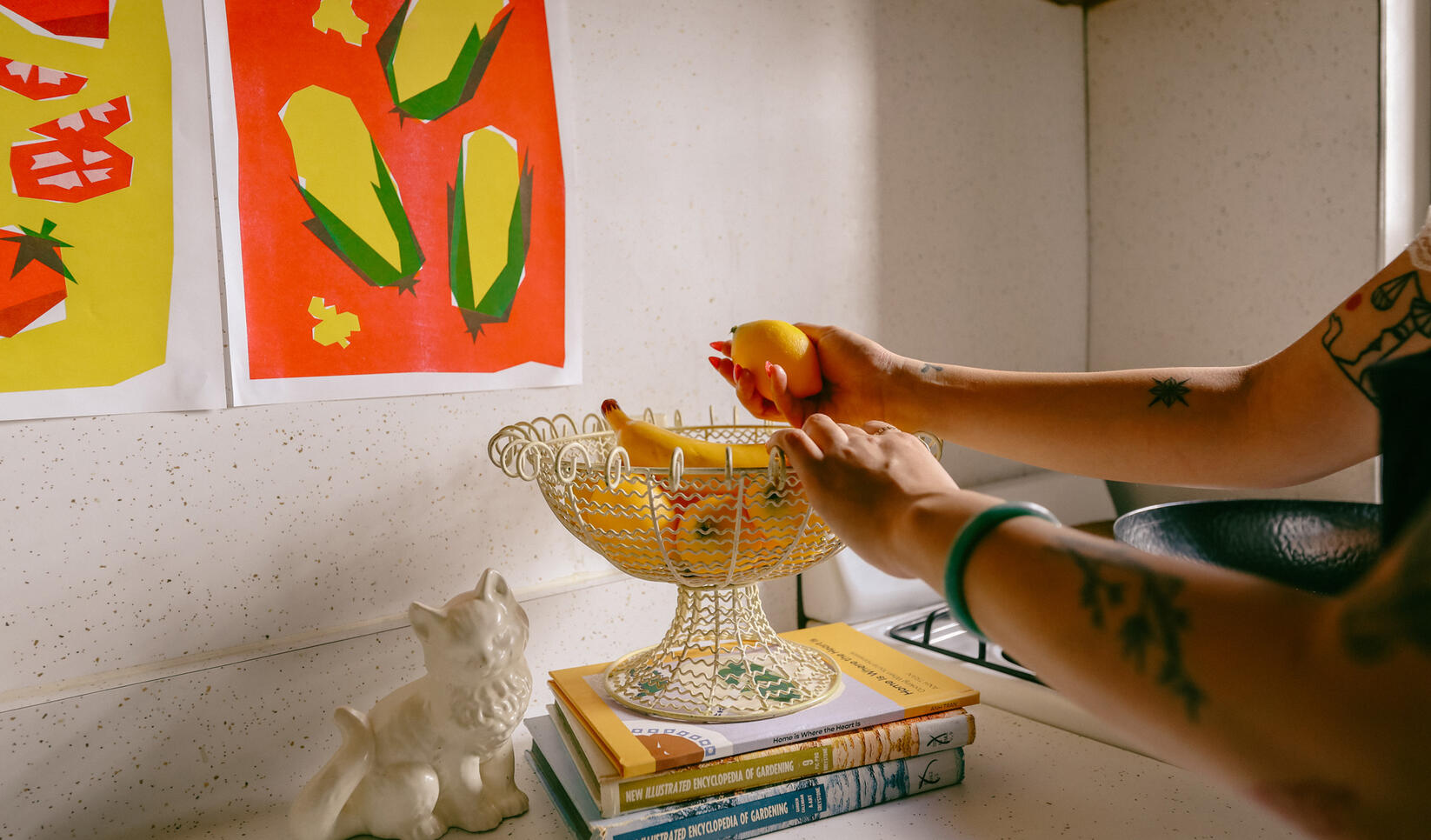 Student grabbing fruit out of a bowl on the kitchen counter