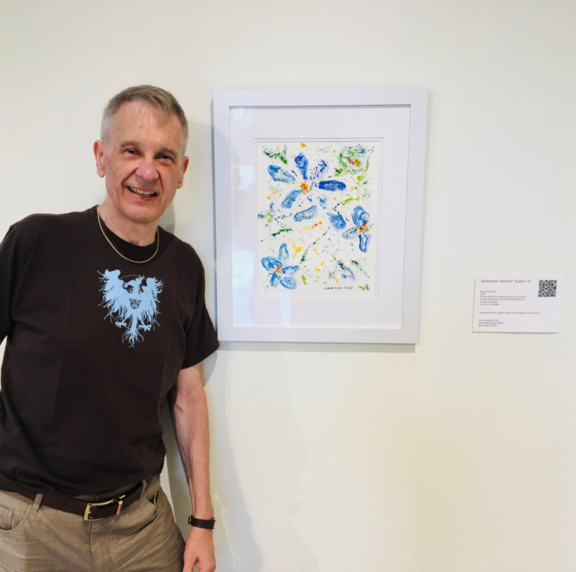 Woody Olsen standing along side his original watercolor painting ; Woody Olsen