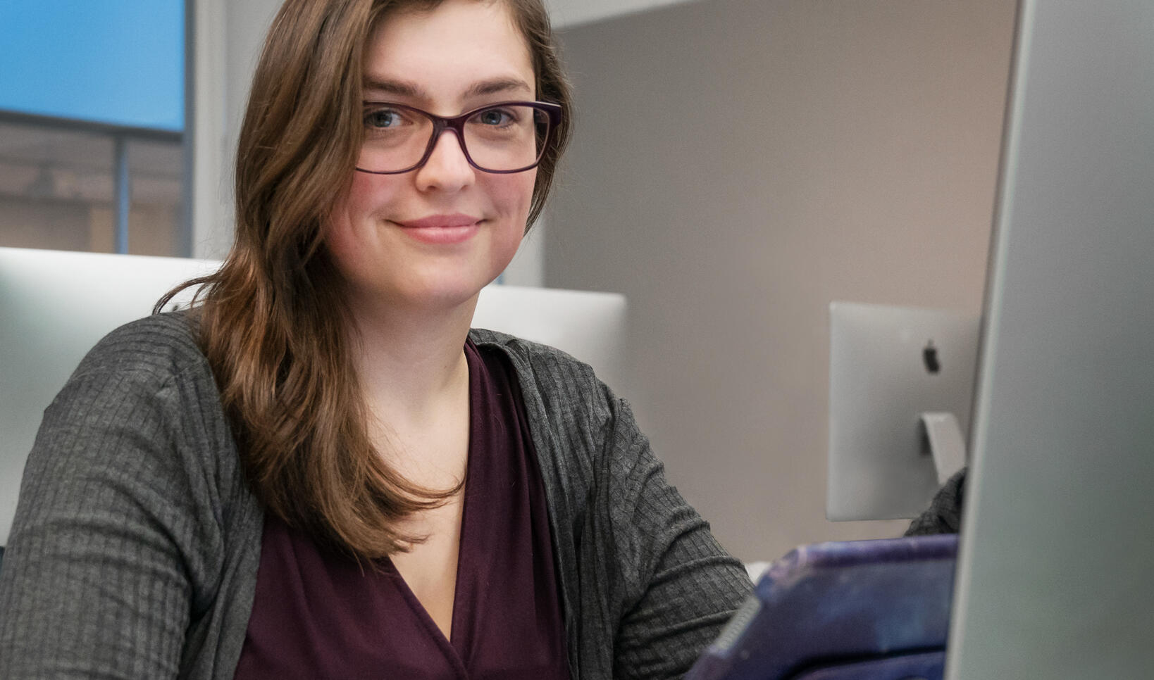 Student sitting at computer with an ipad