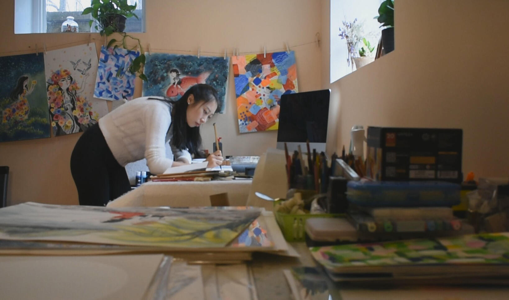A horizontal photograph of Wenmen working in her studio  