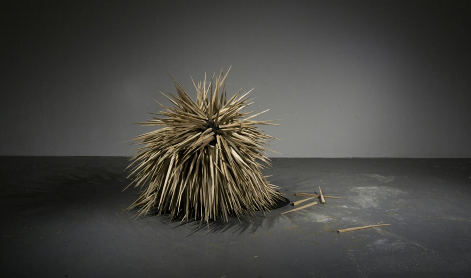 Ball of spikes sits in the middle of black and white room ; Monroe Isenberg