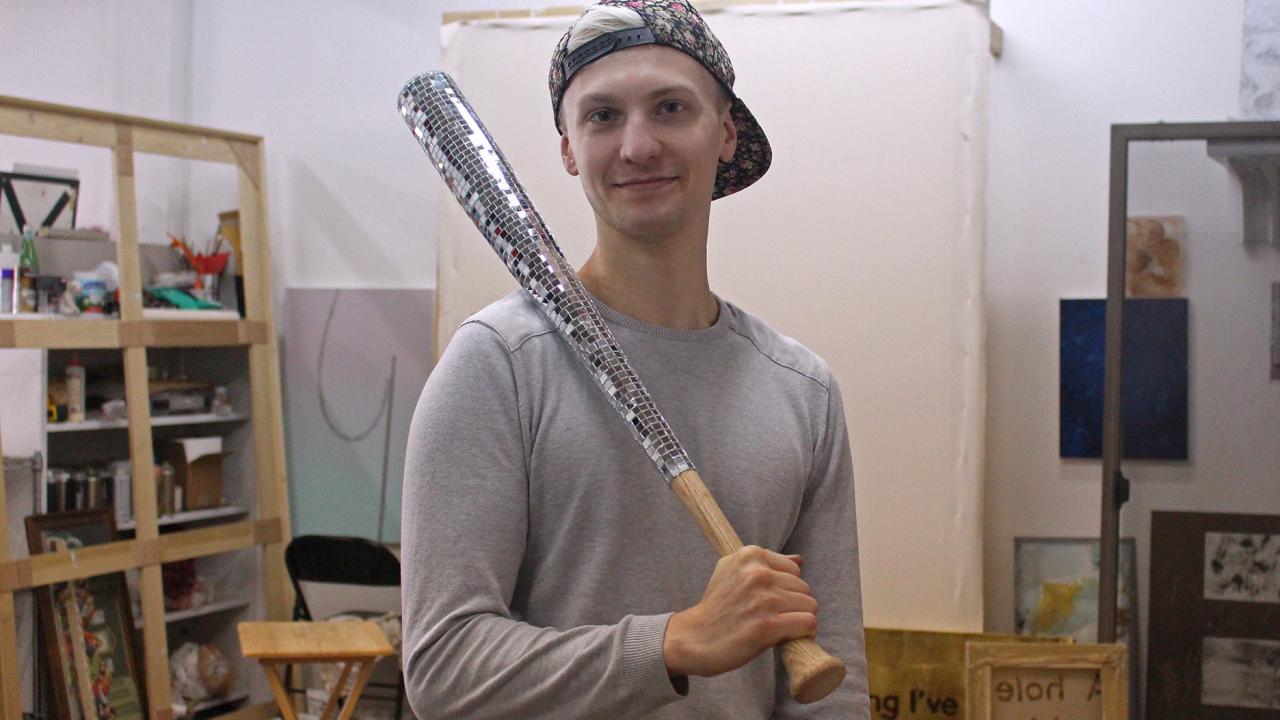 Photograph of Jacob Schroeder holding his baseball bat art piece