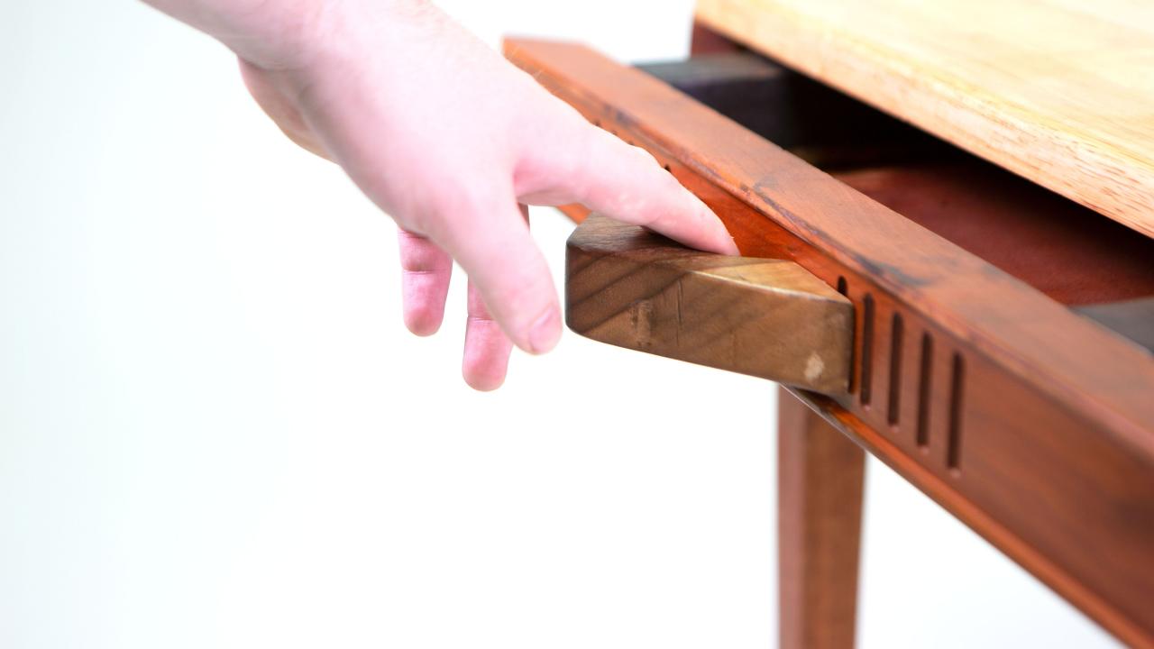 Person pulling drawer of chess table open