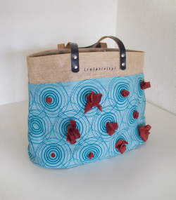 Tote bag composed of different materials, including printed fabric.