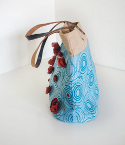 Tote bag composed of different materials, including printed fabric. Side view