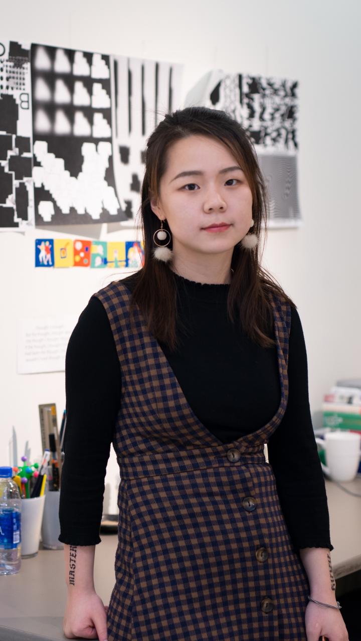 MFA student standing in front of their artwork