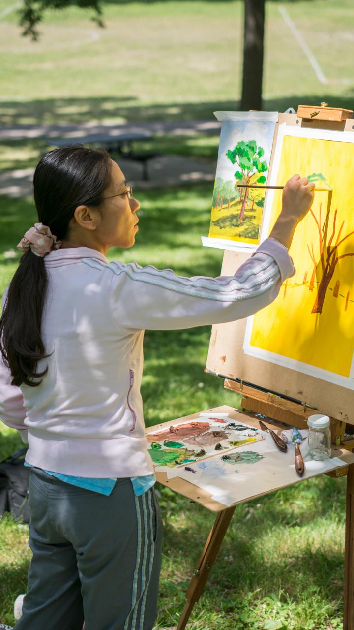 Person painting a landscape outside