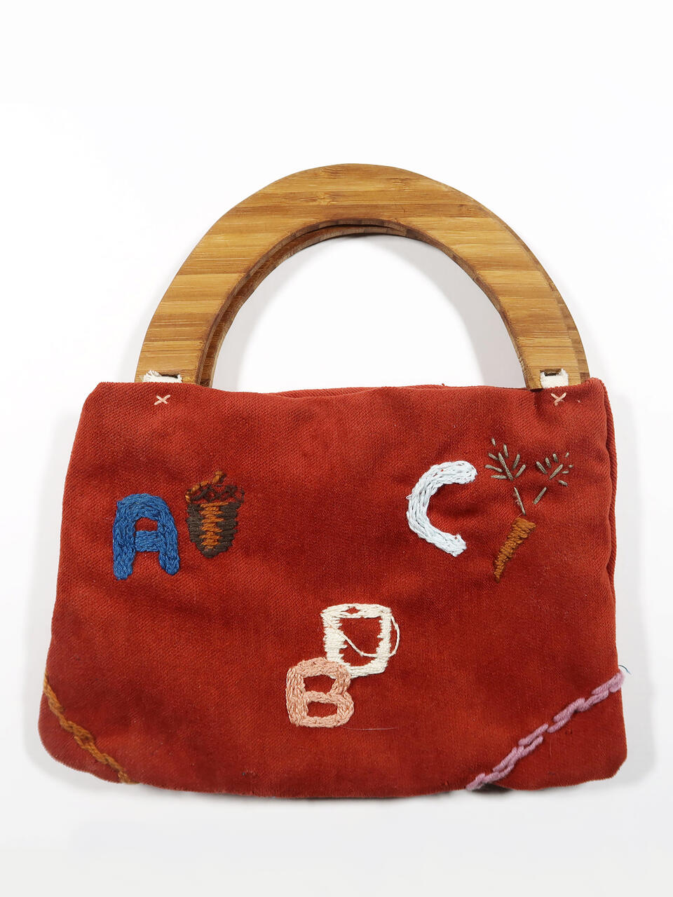 A small red purse featuring stitched letters: A for acorn, B for bucket, and C for carrot.