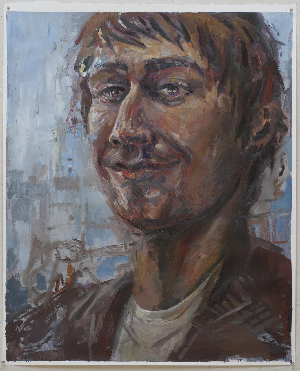 Painting self portrait of artist pictured with pale blue background.