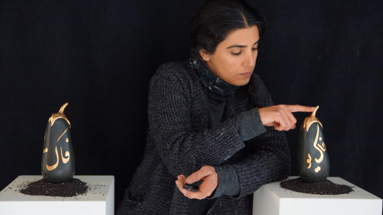 Katayoun Amjadi posing with her eggplants sculpture