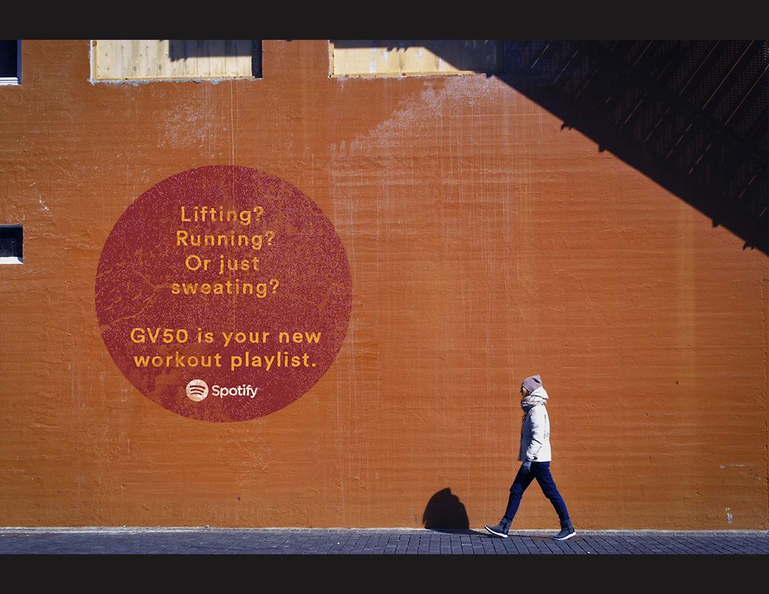 Bus, wall, and poster advertisements for Spotify's viral top 50 playlist.