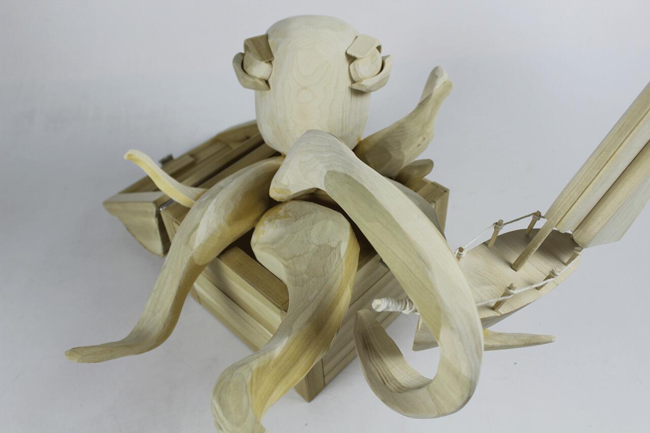 Wooden sculpture of octopus and ship.