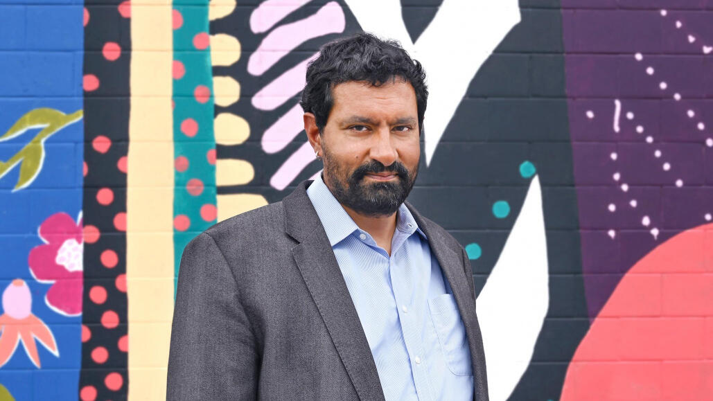 Portrait of Sanjit Sethi in front of the MCAD mural