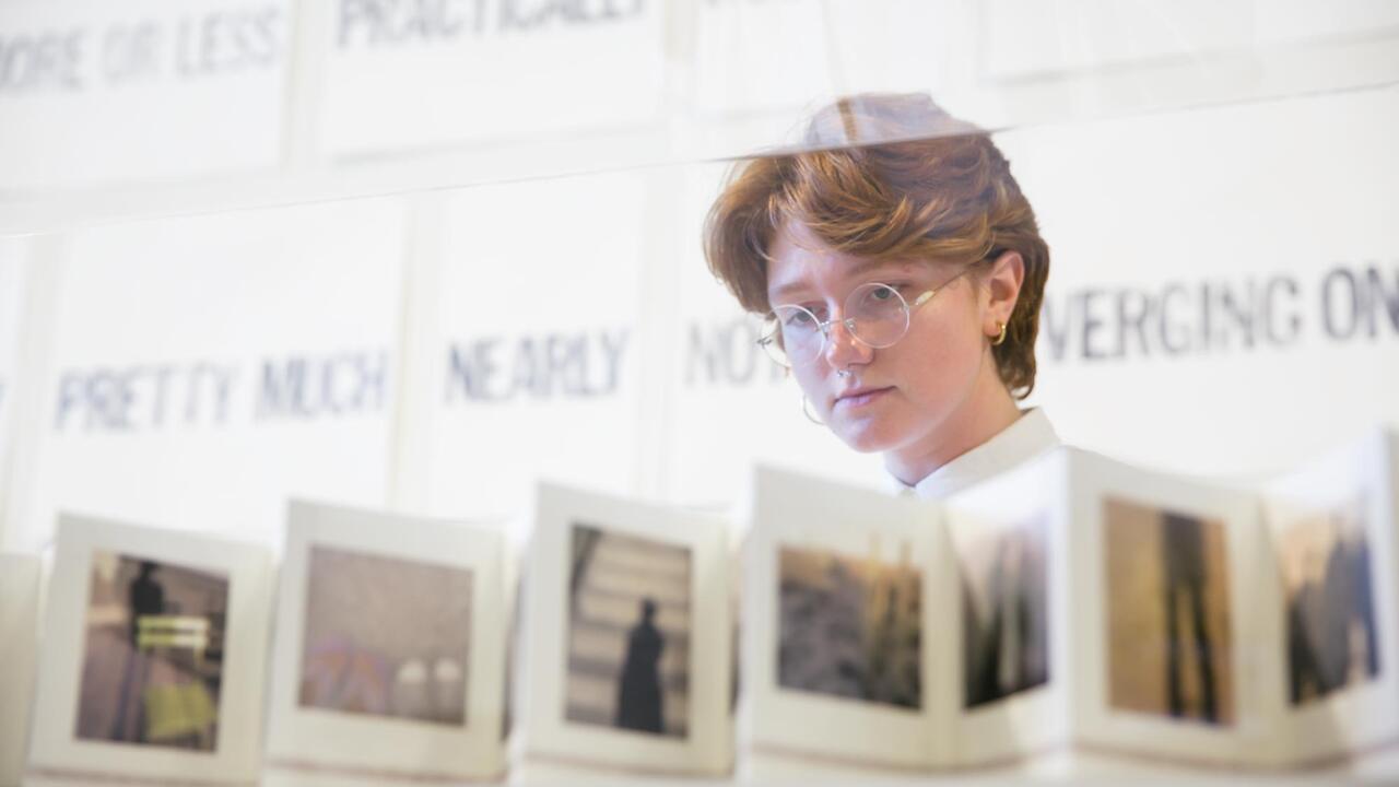 Person looking at an artist book at the MCAD Faculty Biennial
