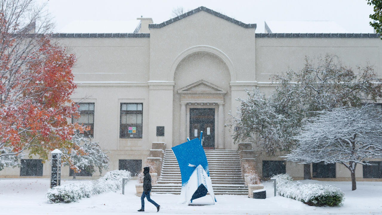 Person walking in front of Morrison Building during the winter